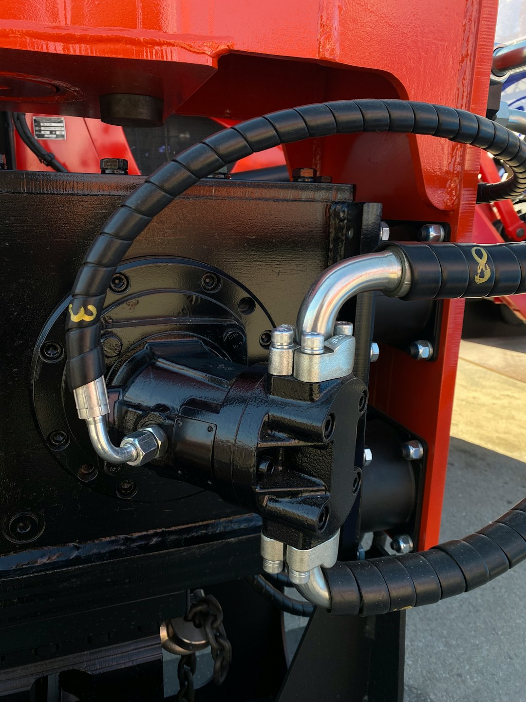 Industrial hydraulic components mounted on a bright orange frame.