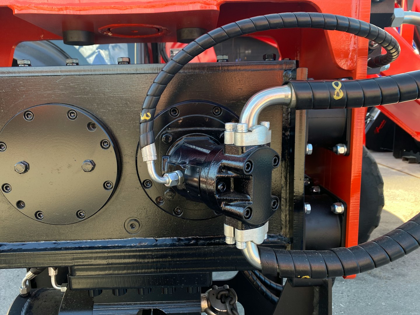 Hydraulic pump and hoses mounted on heavy industrial machinery.
